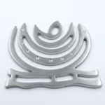 Close-up of zinc helix Vastu remedy showing metallic finish and crescent shape